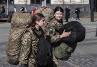 two women in military uniforms walking down the street