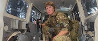 a woman in a military uniform sitting in the back of a vehicle