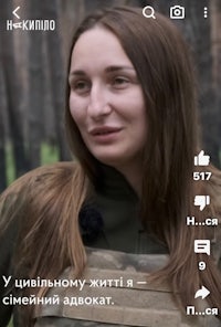 a woman in a military uniform is standing in a forest
