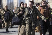 a group of women in military uniforms walking down the street