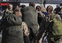 a group of women in military uniforms walking down the street